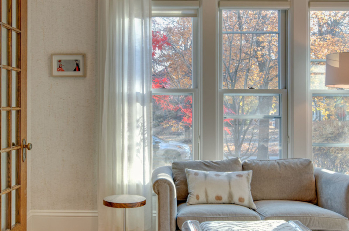 sitting area with small side table, loveseat, artwork, and printed lumbar pillow