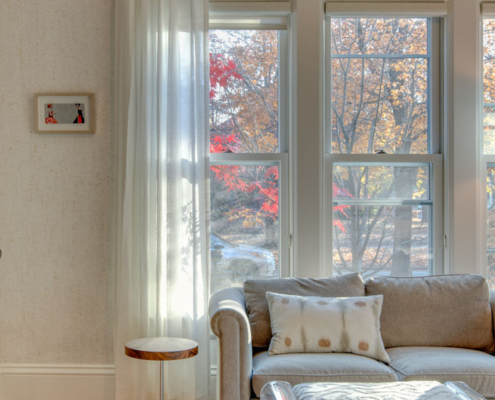 sitting area with small side table, loveseat, artwork, and printed lumbar pillow