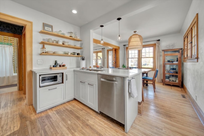 Kitchen with live shelves and view into dining room with basket light