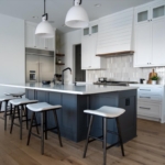 blue kitchen island with white cabinets, natural tile backsplash, wood floating shelves