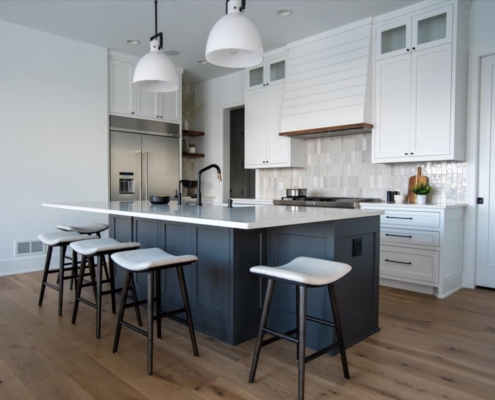 blue kitchen island with white cabinets, natural tile backsplash, wood floating shelves