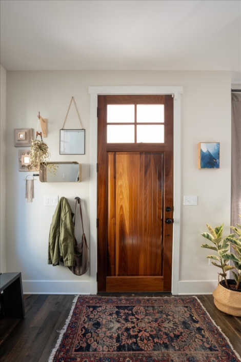 Front door vignette, art, hooks, mirror, plant, global rug