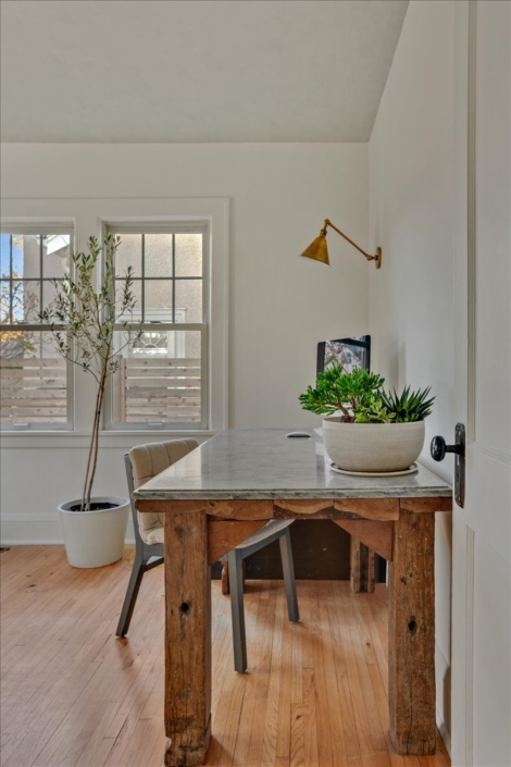 Office space with desk, sconce, and plants