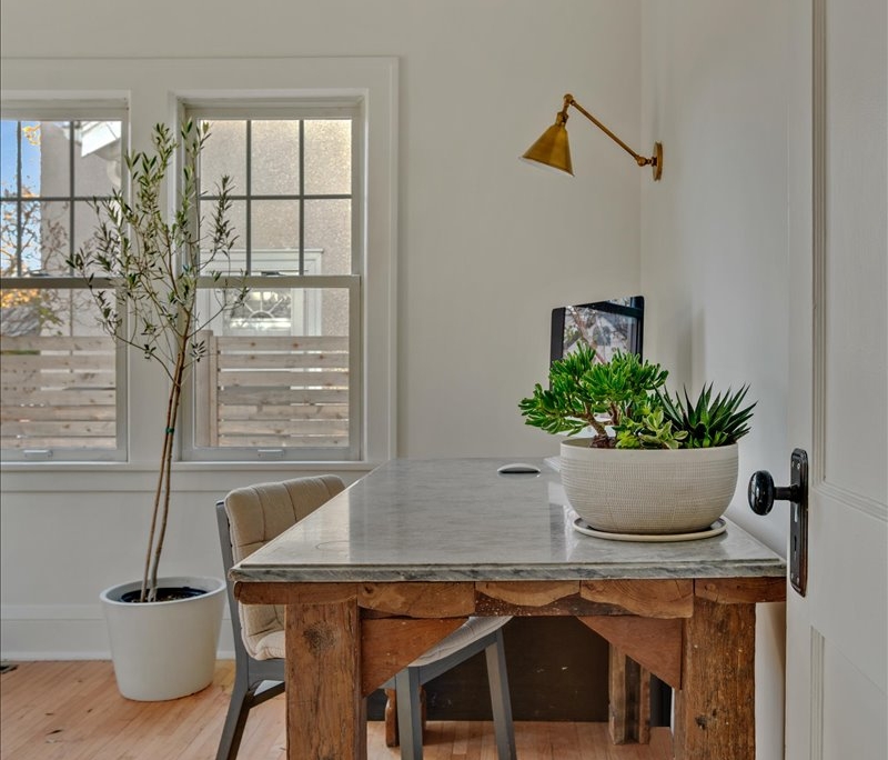 Office space with desk, sconce, and plants