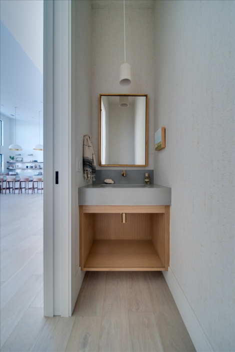 Powder Room floating vanity with cement sink and cork wallpaper