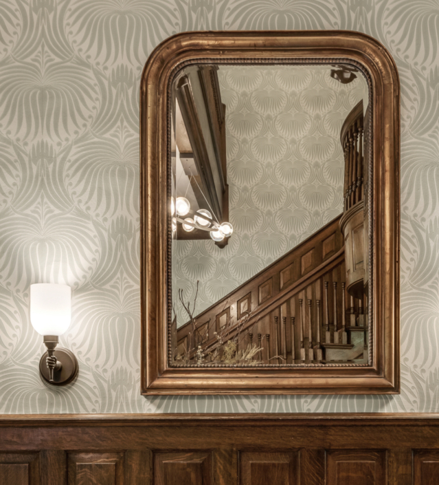 Entry mirror with hand sconce and wallpaper