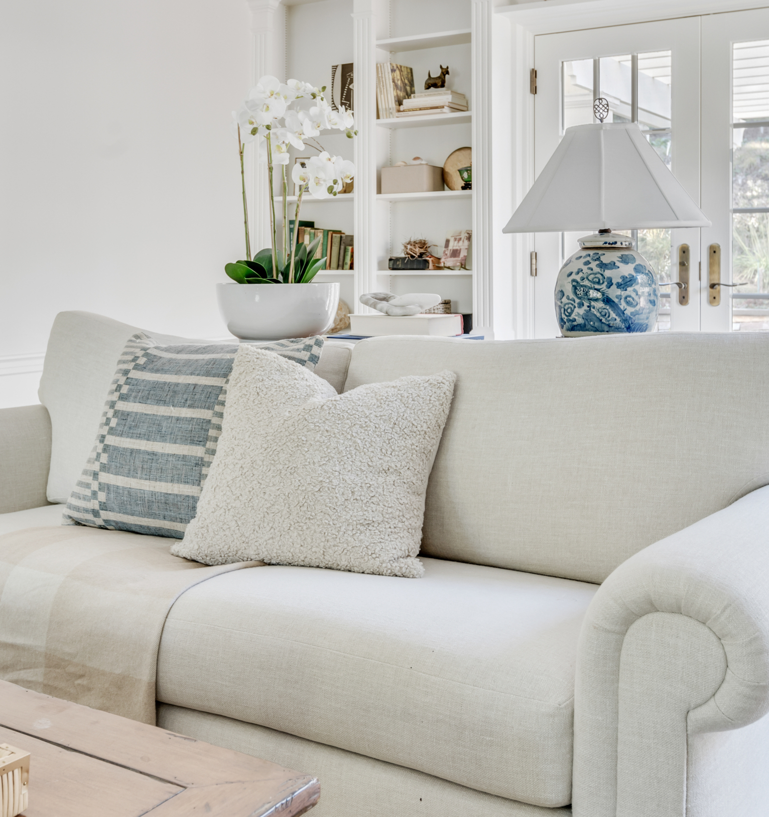 couch with pillows and ginger jar lamp