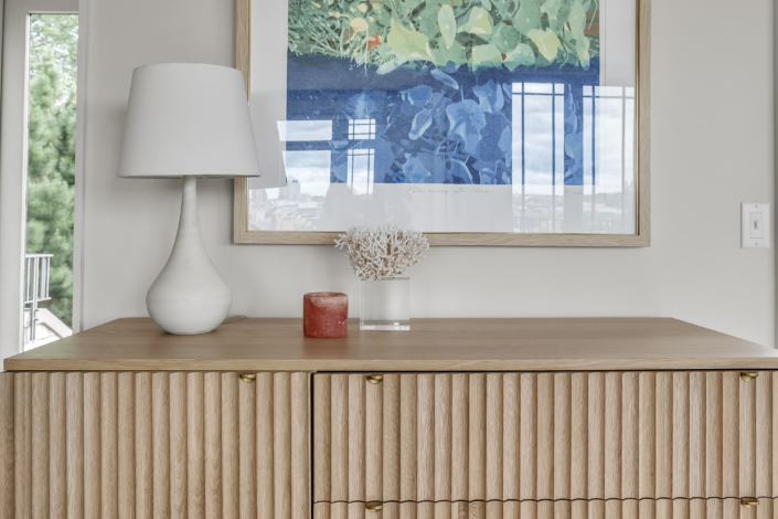 Sideboard with colorful art, white lamp and candle