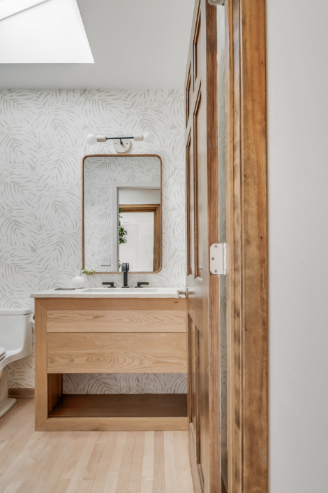 Bathroom with wood vanity and wallpaper