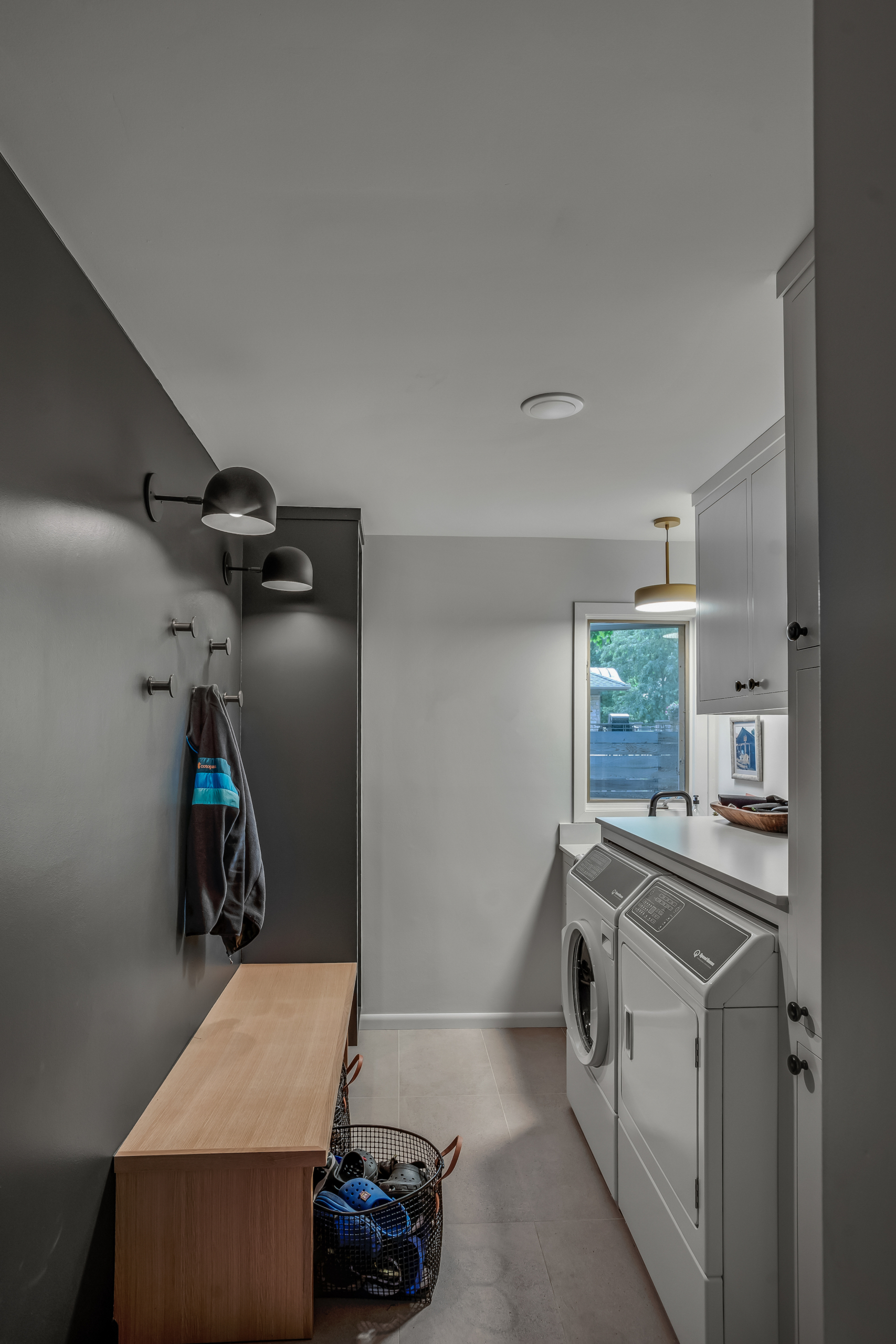 Mudroom with black wall and sconces