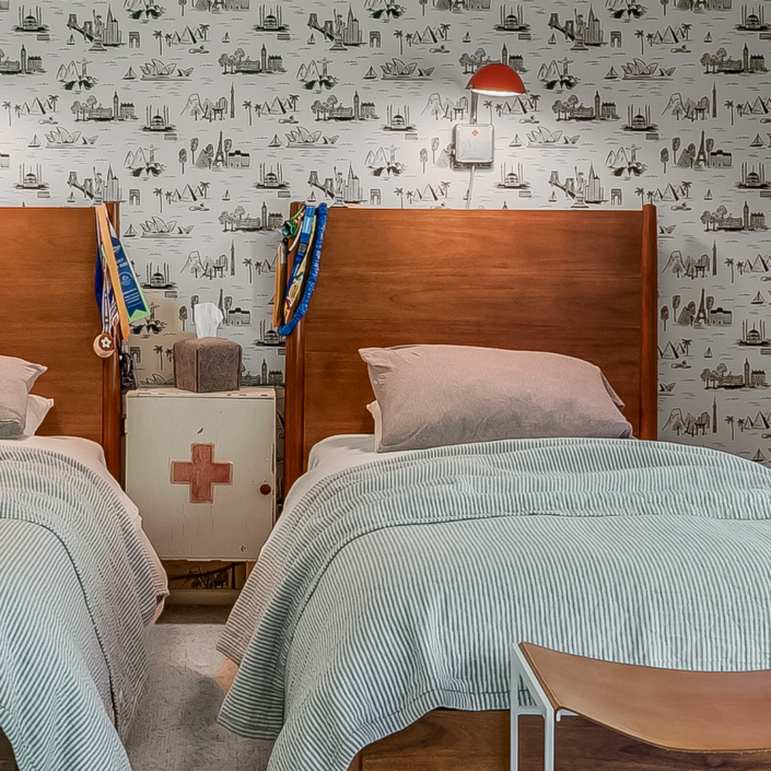 twin beds with red sconce and wallpaper