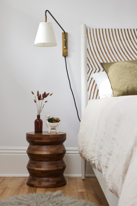 bed with sconce and nightstand